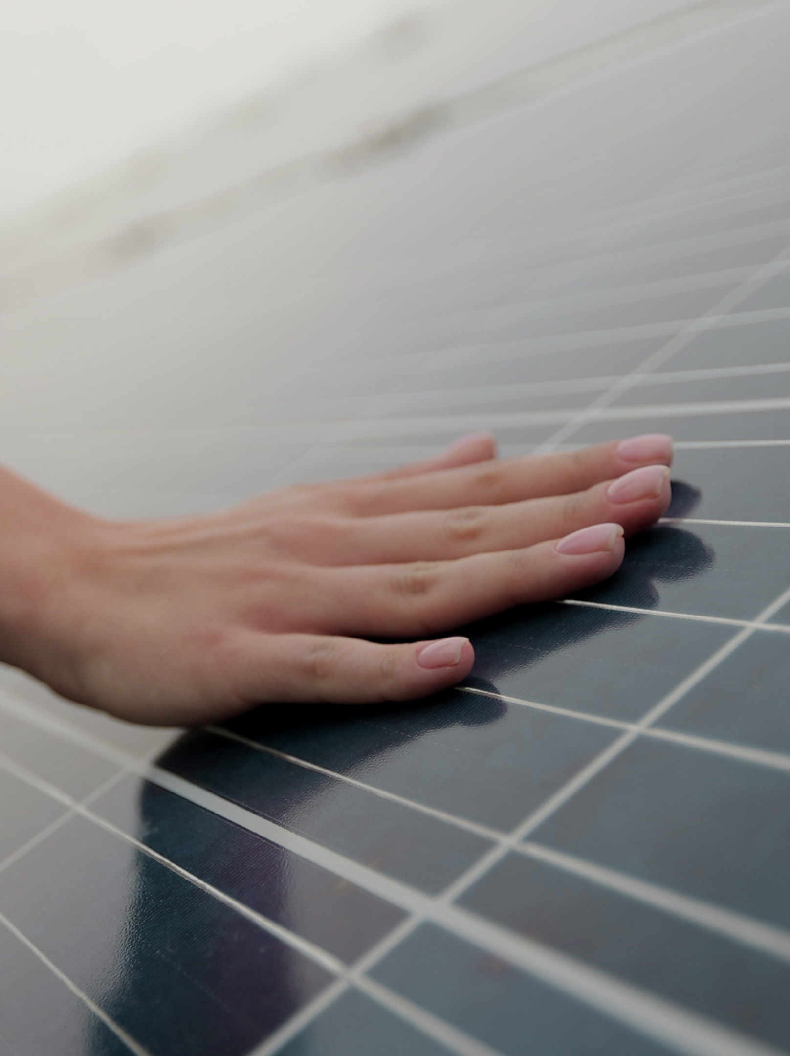Close up of woman engineer hand is checking with solar panels. The worker’s hand and the solar panel during the sunset. Concept for ecology. Solar farm. Clean energy concept.
